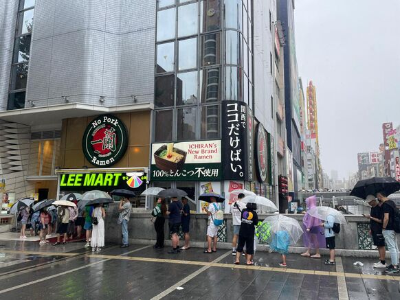 Foto gemaakt door Sterre en Toon - Osaka - In de rij voor een restaurant, hoe slecht het weer ook is. 